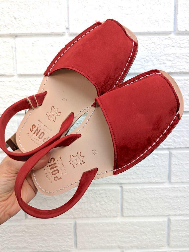 Red sandals on white brick