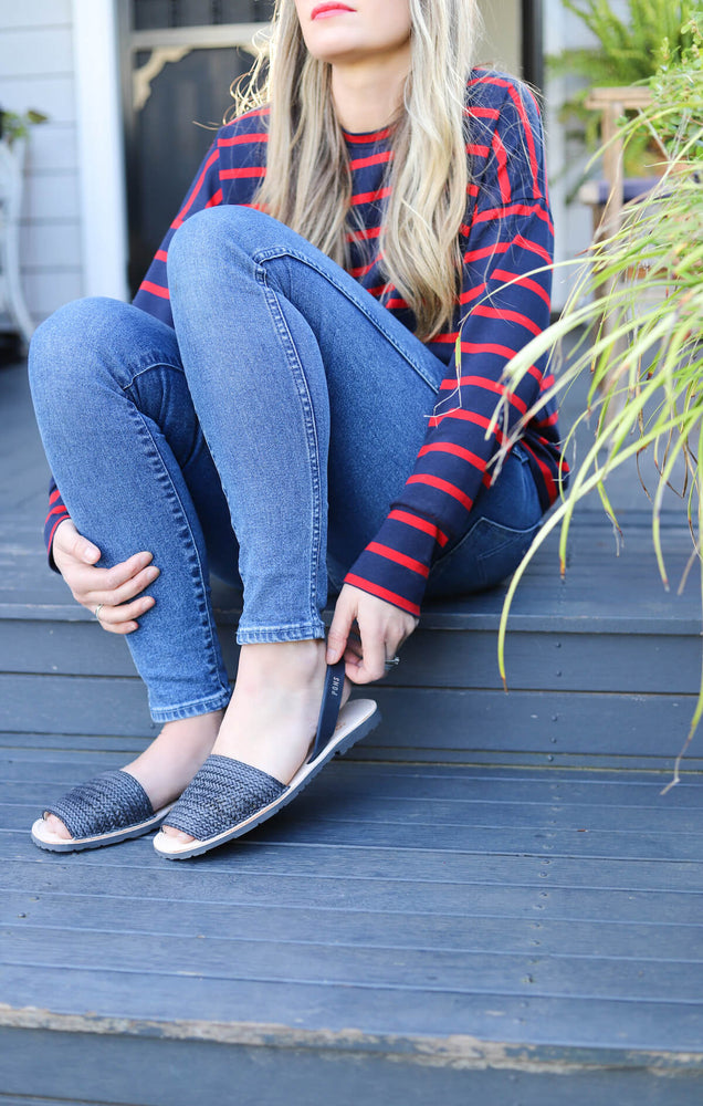 Styled with denim, lady sitting down wearing sandals
